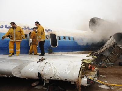 Feuerwehrleute auf dem Wrack der verunglückten Maschine im Iran. Flugzeugunglück