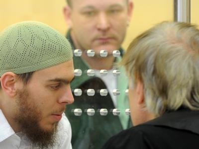 Der Angeklagte Daniel Schneider spricht durch eine Glasscheibe mit seinem Anwalt Bernd Rosenkranz. Sauerland-Prozess