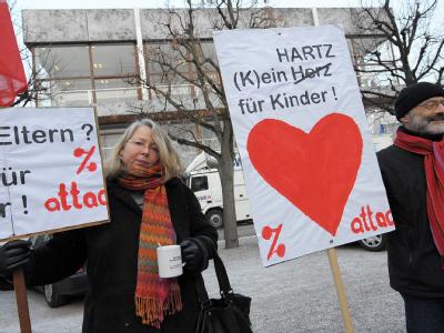 Mitglieder von Attac protestieren mit Transparenten vor der Urteilsverkündung zu den Hartz-IV-Regelsätzen vor dem Bundesverfassungsgericht in Karlsruhe. Noch mehr Protest