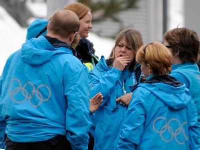 Geschockte ehrenamtliche Helfer am Rand der olympischen Rodelstrecke. Geschockte Helfer