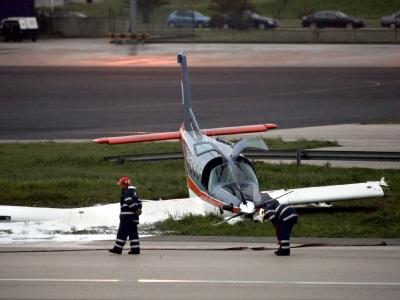 Feuerwehrleute stehen am Wrack der notgelandeten Maschine auf dem Flughafen von Tires. Notlandung