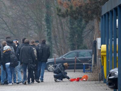 Schüler stehen vor der Berufsschule in Ludwigshafen, in der ein Lehrer getötet wurde. Bluttat an einer Schule