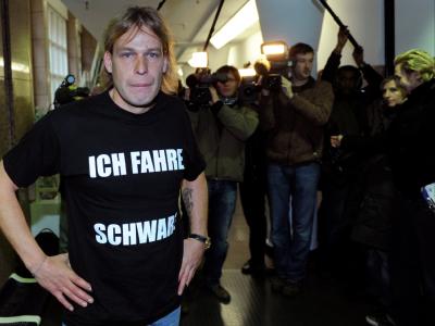 Silvio B. zeigt sein T-Shirt mit dem Aufdruck Schwarzfahrer vor Gericht