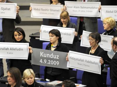 Die Linksfraktion hält im Bundestag Plakate mit den Namen der bei dem Angriff auf zwei Tanklastzüge getöteten Personen hoch. Bundestag