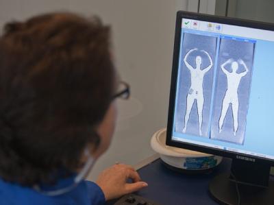 Eine Mitarbeiterin der Flughafensicherheit in Boston schaut auf ihrem Monitor auf die Figur einer Frau, die von einem Ganzkörperscanner durchleuchtet wurde (Pressevorführung). Körperscanner