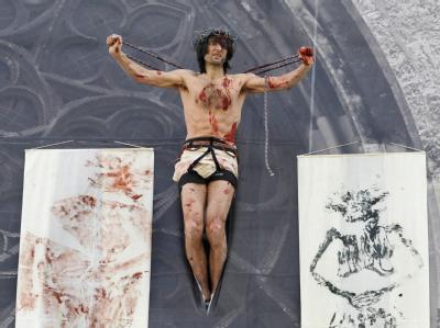 Der österreichische Künstler Emmerich Weissenberger in der Pose des gekreuzigten Jesus. Kunstaktion gegen Missbrauchsfälle