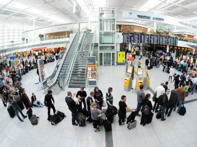 Menschen warten vor den Schaltern am Münchner Flughafen. Warteschlange