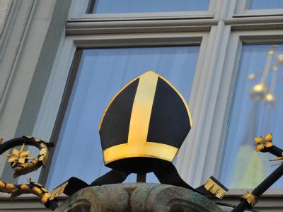 Das Kreuz des Doms spiegelt sich in Augsburg in einem Fenster am Bischofspalais. Augsburg