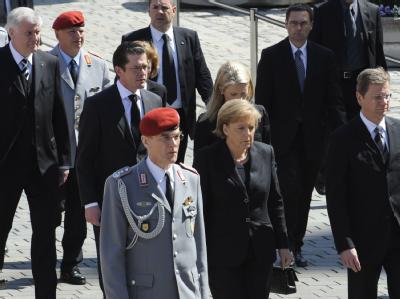 Bundeskanzlerin Merkel, Außenminister Westerwelle (r), Verteidigungsminister Guttenberg und Bayerns Ministerpräsident Seehofer (l) gehen zum Münster in Ingolstadt. Zentrale Trauerfeier für getötete Soldaten