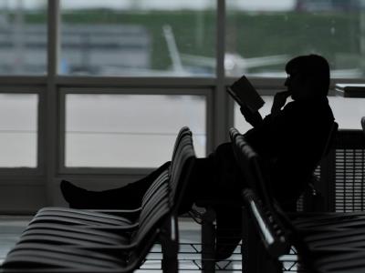 Ein Passagier sitzt im Abflugbereich des Münchner Flughafens. Vulkanasche führt erneut zu Flugverboten