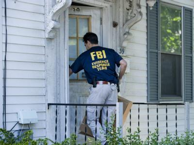 Ein FBI-Agent verschafft sich Zugang zu einem Haus in Watertown, Massachusetts. Razzien nach Times-Square-Bombe