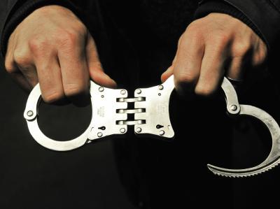 Ein Zivilfahnder der Polizei zeigt seine Handschellen. Polizeiliche Kriminalstatistik
