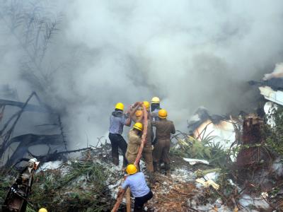 Feuerwehrmänner versuchen, das brennende Wrack zu löschen. Flugzeugabsturz in Mangalore