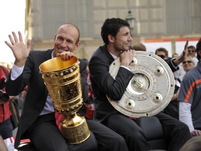 Bayern-Kapitän Mark van Bommel (r.) trägt die Meisterschale, Arjen Robben den DFB-Pokal. Mark van Bommel und Arjen Robben