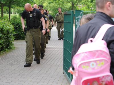 Polizeibeamte gehen über den Hof der Berliner Schule, an der Amok-Alarm ausgelöst worden war. Polizisten an Berliner Schule