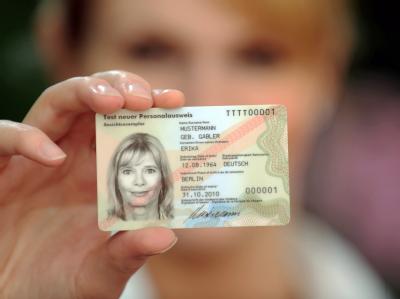 Eine Frau zeigt in der Bundesdruckerei ein Muster des neuen Personalausweises. Vorstellung neuer Personalausweis
