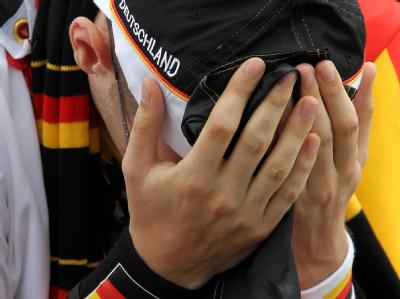 Das kann nicht wahr sein: Ein Fußballfan schlägt auf der Fanmeile in Berlin die Hände vors Gesicht. Fan in Berlin