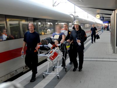 Rettungskräfte versorgen eine kollabierte Schülerin am Bahnhof in Bielefeld. Hitze im defekten ICE lässt Schüler kollabieren