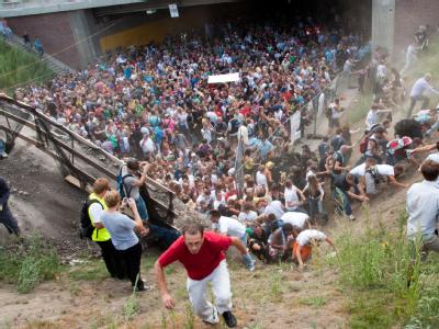 Tausende Raver drängen sich vor dem Tunnel in Duisburg, in dem sich eine Massenpanik ereignet hat. Vor dem Tunnel