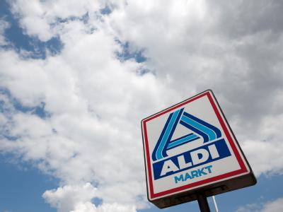 Das Aldi-Logo vor bewölktem Himmel. Aldi