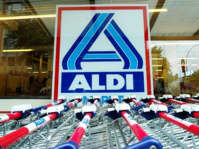 Einkaufswagen stehen vor einer Aldi-Filiale. Aldi