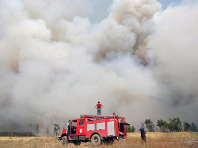 Hilflos betrachten Feuerwehrmänner die riesigen Rauchwolken. Waldbrände in Russland