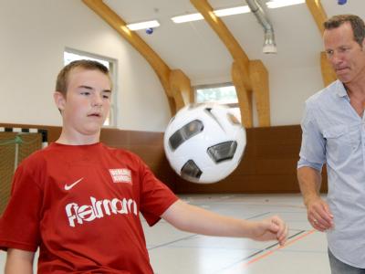Der Ex-Boxweltmeister Henry Maske spielt mit dem 14-jährigen Dennis Fußball.(Archivbild vom 12.08.2010). Er lädt Jugendliche mit Hilfe seiner Stiftung für eine Woche zum Feriencamp nach Brandenburg ein. Ferienreise für Hartz-IV-Kinder