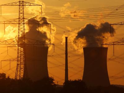 Die untergehende Sonne hinter den Kühltürmen eines Atomkraftwerks. Atomkraftwerk