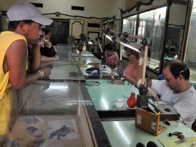 In einem vom Staat betriebenen Laden arbeiten Uhrmacher in Havanna. Uhrmacher