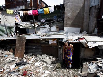 Eine philippinische Frau verlässt ihre Hüte in einem Armenviertel von Manila. Foto: Mike F. Alquinto/Archiv Armut