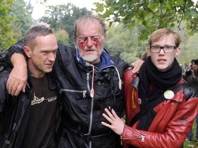 Zwei Männer stützen am 30.09.2010 den verletzten Dietrich Wagner. Stuttgart 21 - Proteste