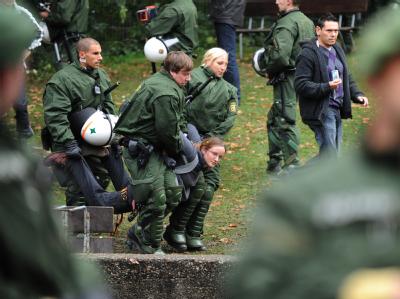 Polizisten tragen im Schlosspark in Stuttgart eine Baumbesetzerin weg, die zuvor von einem Baum geholt wurde. Für das milliardenschwere Bahnprojekt Stuttgart 21 sollen insgesamt 300 Bäume gefällt werden. Baumbesetzerin