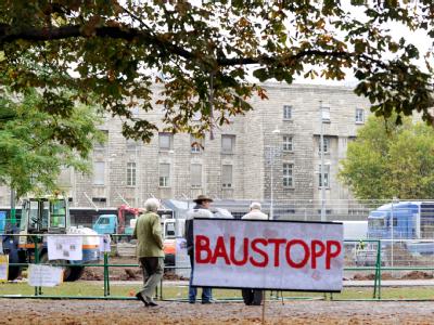 Auf einem Protestplakat im Schlossgarten in Stuttgart fordern Gegner des milliardenschweren Bahnprojekts Stuttgart 21 einen Baustopp. Bahnhof Stuttgart Südflügel
