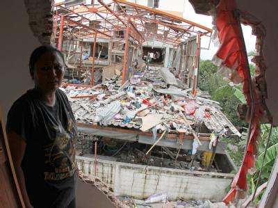 Eine thailändische Frau schaut geschockt aus ihrem beschädigten Haus: Bei der Explosion in Bang Bua Thong 40 Kilometer nördlich von Bangkok sind drei Menschen ums Leben gekommen. Explosion in Thailand
