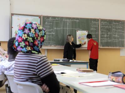 Freiwillige Selbstverpflichtungen könnten nach Ansicht der Regierung an Schulen mit einem hohen Ausländeranteil ein wichtiger Schritt zu besserer Integration sein. (Archivbild) Migrantenkinder im Schulunterricht