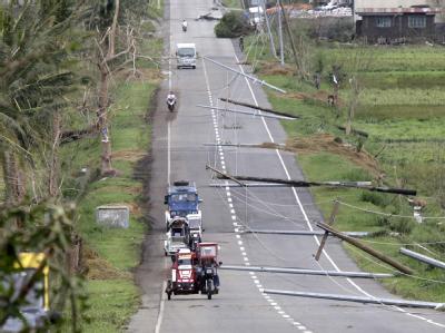 Auf einer Straße im philippinischen Tumauini liegen umgeknickte Strommasten. Taifun Megi verwüstet Teile der Philippinen