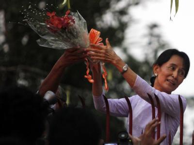 Aung San Suu Kyi nimmt am Zaun ihres Hauses Blumen entgegen. Friedensnobelpreisträgerin Suu Kyi frei