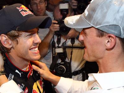 Der deutsche Rekordweltmeister Michael Schumacher beglückwünscht Sebastian Vettel nach seinem Sieg in der Formel-1-Weltmeisterschaft. Formel 1 GP Abu Dhabi - Vettel wird Weltmeister