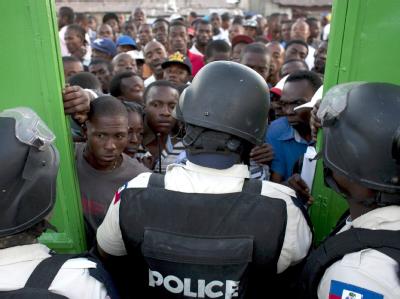 Polizisten lassen Wähler in Port-au-Prince in ein Wahllokal. Bei den Wahlen in Haiti hat es zahlreiche Probleme gegeben. Wahlen in Haiti