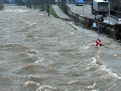 Wassermassen überfluten in Freiburg einen Radweg am Ufer des Schwarzwaldflüsschens Dreisam. Ein Mann wurde von den Fluten mitgerissen, als er versuchte, sein Rad zu retten. Hochwasser Dreisam
