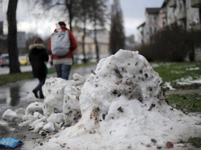 Die Reste eines Schneemanns liegen in Kassel auf dem Bürgersteig. Nach dem großen Auftauen kommt die Kälte jetzt zurück. Tauwetter