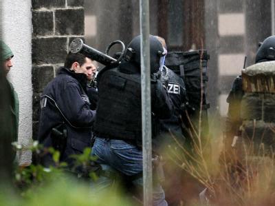 Polizeibeamte eines Sondereinsatzkommandos bereiten in Kruft die Stürmung des Wohnhauses vor. Schießerei in Kleinstadt