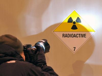 Ein Bildreporter fotografiert ein Hinweisschild an einem der Castor-Transporter mit Atommüll. Vorsicht: 'Radioactive'