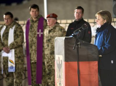 Kanzlerin Merkel (CDU) bei einer Gedenkfeier für einen Bundeswehrsoldaten, der während ihres Besuches bei einem Unglück zu Tode kam. Foto: Foto: Steffen Kugler/Bundespresseamt dpa +++(c) dpa - Bildfunk+++ Merkel in Afghanistan