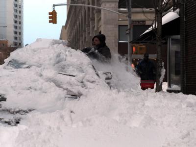 New York City: Ein Mann «sucht» unter dem Schnee nach seinem Auto. New York City