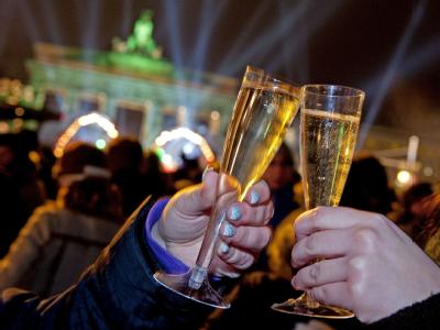 Besucher stoßen während der Open-Air- Silvesterparty vor dem Brandenburger Tor in Berlin auf der Straße des 17. Juni an. Berliner Silvester-Meile