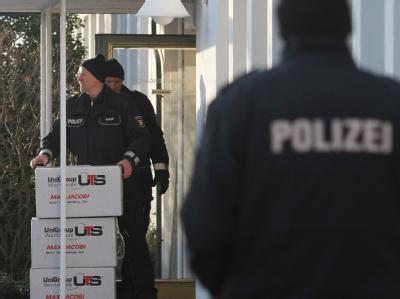 Polizeibeamte tragen Kisten mit beschlagnahmten aus dem Firmensitz der Firma Harles und Jentzsch in Uetersen. Harles und Jentzsch