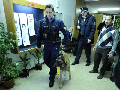 Ein Polizist verlässt mit einem Sprengstoffhund die Kirche der koptischen St.-Markus-Gemeinde in Frankfurt/Main. Koptische Gemeinde feiert Weihnachten unter Polizeischutz