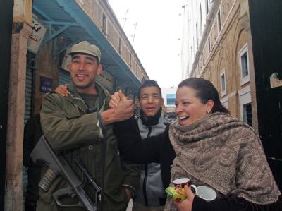 Eine tunesische Frau posiert zusammen mit einem Soldaten für den Fotografen. Straßenszene in Tunis