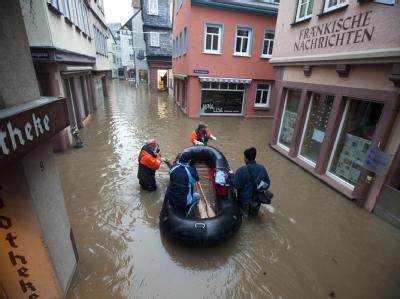 Feuerwehrleute bugsieren am Montagmorgen in Wertheim am Main ein Schlauchboot mit einer Frau durch die überfluteten Gassen der Innenstadt. Die Einsatzkräfte bereiteten sich hier auf die zweite Hochwasserwelle innerhalb einer Woche vor. Hochwasser in Wertheim